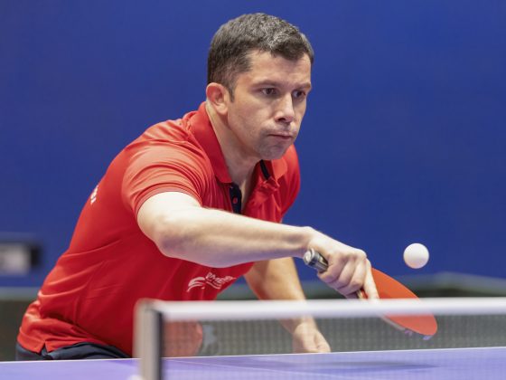 A player in red shirt plays a shot.