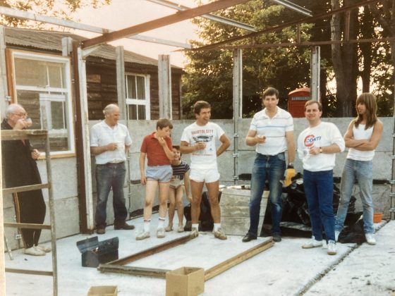 A small group stands in a part built building