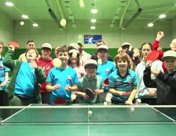 Group of children throw table tennis balls, smiling and laughing